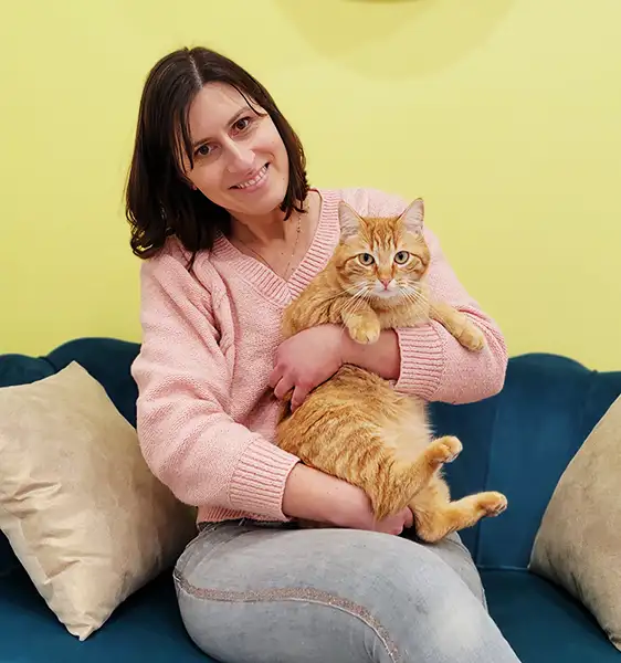 Delphine Meunier, la gérante de la pension pour chats Henricat. Assise, elle tient dans ses bras un chat roux.